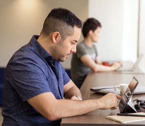 Adult student with a laptop on a table