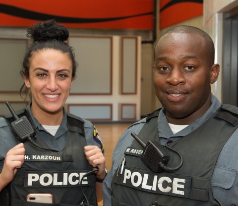 UPD officers Hadeel Karzoun and Maxwell Ravenell III facing the camera and smiling