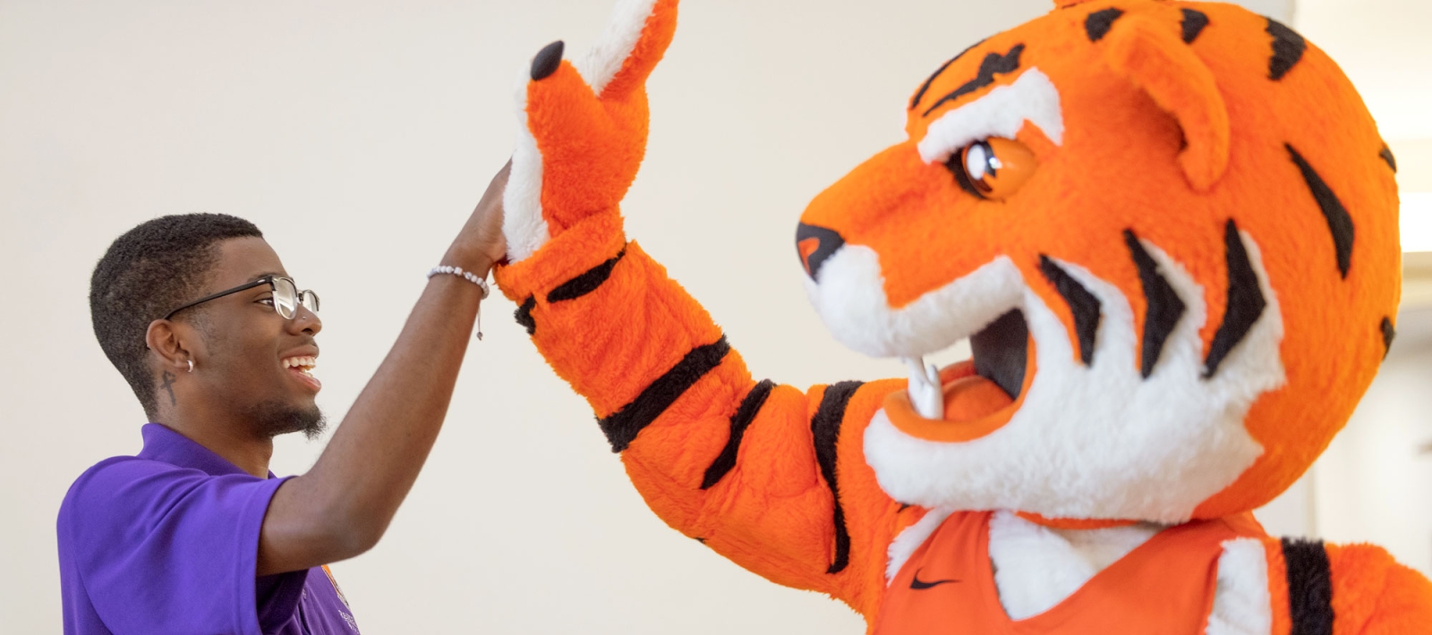 Bengal and student high-fiving each other